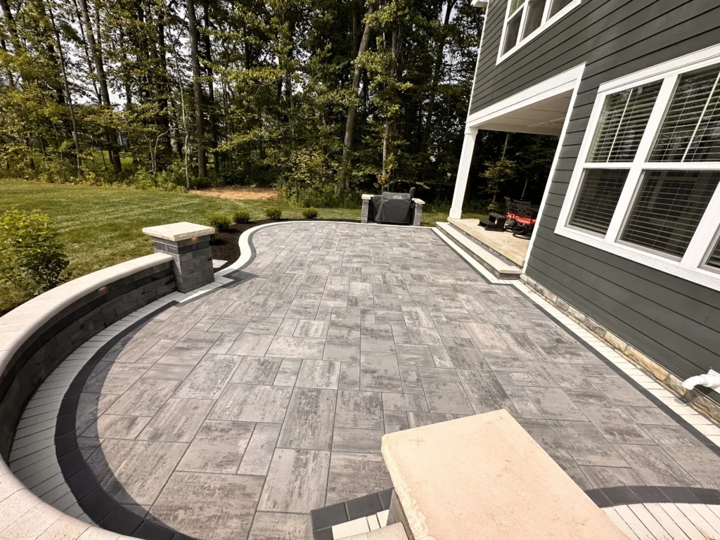Curved paver patio with seat walls and lit columns - Johns Creek, GA hardscaping contractor | Viral Spark Marketing