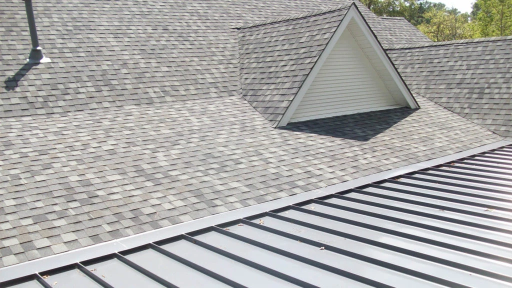 Roofing crew member walking on a finished Johns Creek roof during golden hour