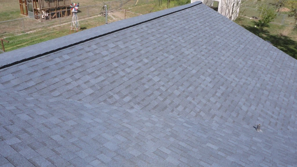 Roofing crew member checking installation quality on a Johns Creek home